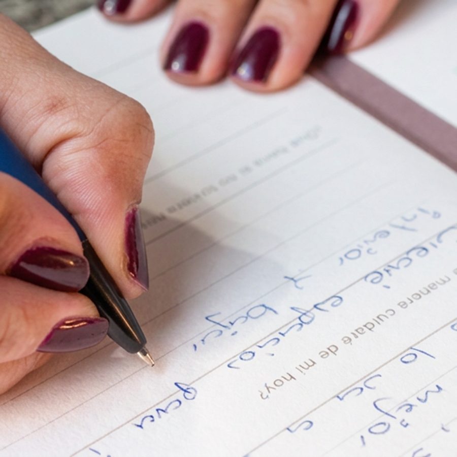 Mano escribiendo en un diario, escritura terapéutica